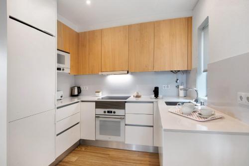 a kitchen with white appliances and wooden cabinets at Pear Tree Villa in Vale do Lobo