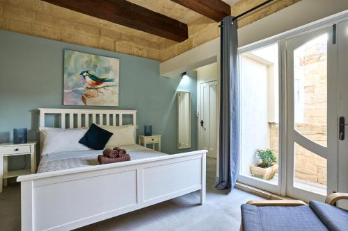 a bedroom with a white bed with a teddy bear on it at 12 -16 , Pacifiku Scicluna in Birgu