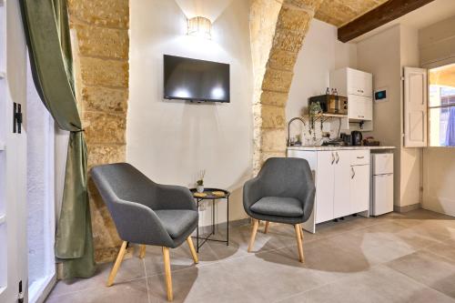 a living room with two chairs and a table at 12 -16 , Pacifiku Scicluna in Birgu