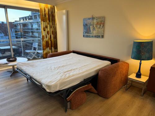 a bedroom with a bed and a large window at SilverSunSet De Haan in De Haan