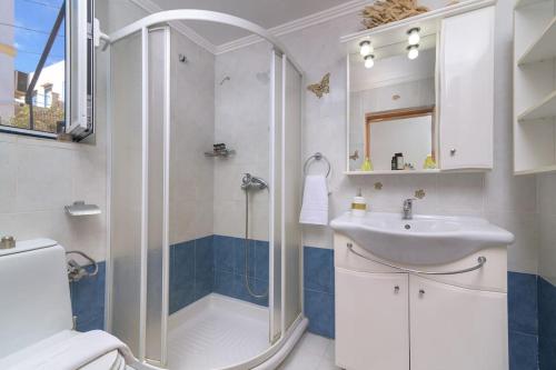 a bathroom with a shower and a sink at Yellow Oasis traditional home with sea view in Halki