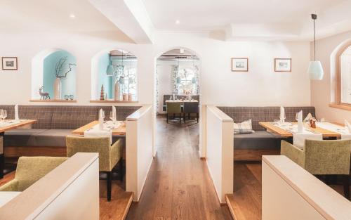 a restaurant with white walls and tables and chairs at POP-UP LIVING Zell am See in Zell am See