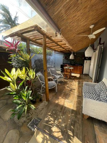 a covered patio with chairs and a ceiling at Canto das Laranjeiras MOA in Guarujá