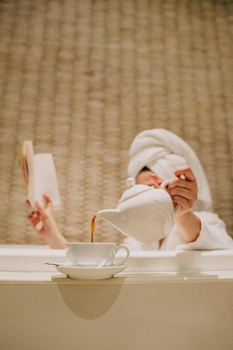 a baby is sitting on a table reading a book at Mirfa Hotel in Al Marfaʼ