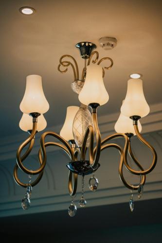 a chandelier with four lights on a ceiling at Mirfa Hotel in Al Marfaʼ