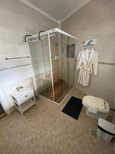 a bathroom with a shower stall and a toilet at Canto das Laranjeiras MOA in Guarujá