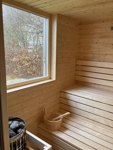 a wooden sauna with a window and a basket at Arboretum in Vlasenice