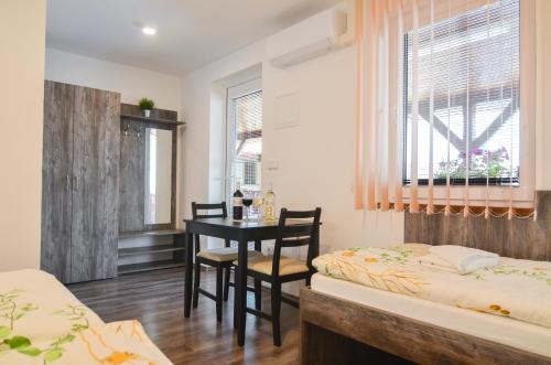 a bedroom with a desk and a table and two beds at Penzion Zaječák in Zaječí