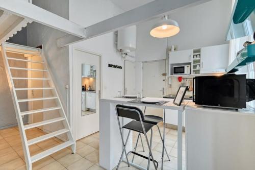 - une cuisine blanche avec un bureau et une chaise dans l'établissement Le Marseillais - Vieux Port, à Marseille