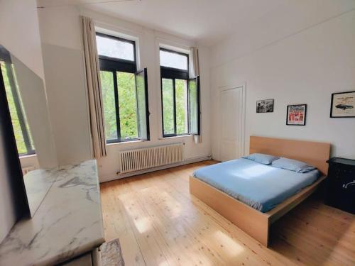 a bedroom with a bed in a room with windows at Appartement Manhattan 4 pers in La Madeleine