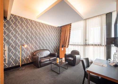 a waiting room with leather chairs and a table at Hotel Spa Le Pasino in Le Havre