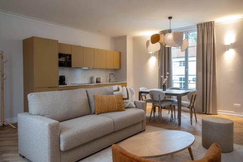 a living room with a couch and a table at L'Horloge - Appart'Hotel proche de Disneyland in Montévrain