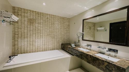 a bathroom with two sinks and a large mirror at Mirfa Hotel in Al Marfaʼ