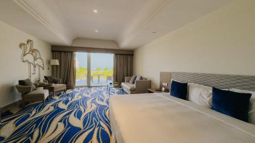 a hotel room with a bed and a living room at Mirfa Hotel in Al Marfaʼ