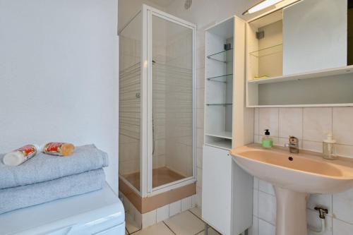 une salle de bain blanche avec un lavabo et une douche dans l'établissement Le Provençal - Vieux Port, à Marseille