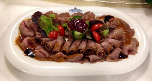 a plate of food with meat and vegetables on a table at EA Hotel Atlantic Palace in Karlovy Vary