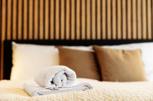 a white towel on a bed with pillows at OrestaLiving - BrigittineurLände in Vienna