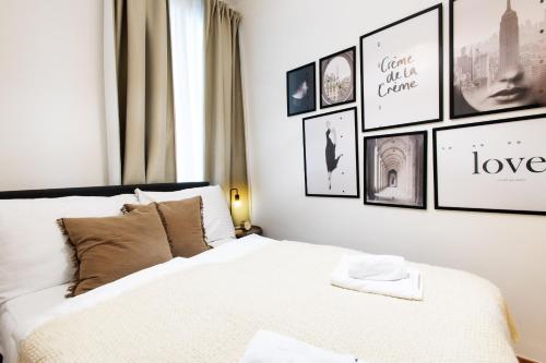 a bedroom with a bed with pictures on the wall at OrestaLiving - BrigittineurLände in Vienna