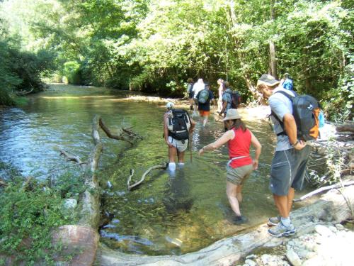a group of people crossing a stream in the water at B&B Colle Perrini Country House in Casperia