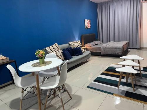a living room with a couch and a table and chairs at Alinea Suites Seksyen 14 in Shah Alam