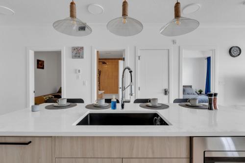 a kitchen with a sink with three dishes on it at Bright Condo with Balcony & Free Parking in Calgary