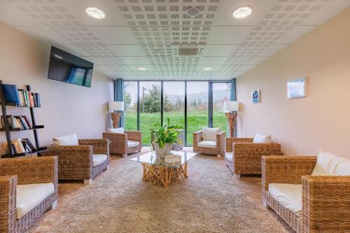 - une salle d'attente avec des chaises en osier et une table dans l'établissement Appart’City Confort Vannes, à Vannes