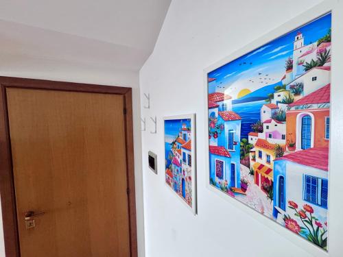 two paintings on a wall next to a door at Le paperelle in Ortona