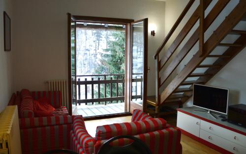 - un salon avec deux chaises et une porte coulissante en verre dans l'établissement Hostdomus - Casa Borgata, à Borgata Sestriere