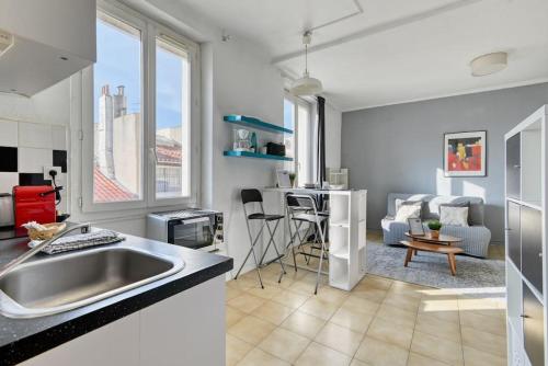 une cuisine avec un évier et un salon dans l'établissement Le Grand Provençal - Vieux Port, à Marseille