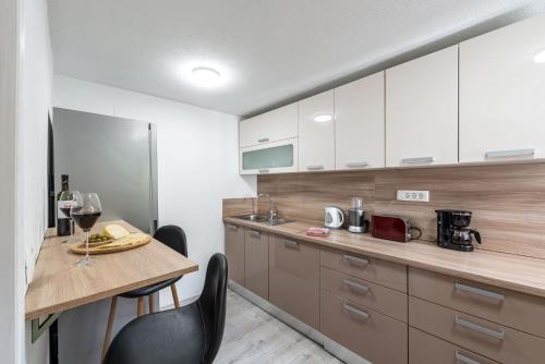 a kitchen with white cabinets and a table and chairs at Villa Dovecote with Private Sauna, Jacuzzi & Gym in Ston