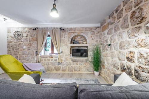 a living room with a stone wall at Villa Dovecote with Private Sauna, Jacuzzi & Gym in Ston