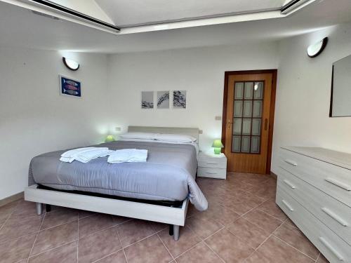 a white bedroom with a bed and a dresser at Le paperelle in Ortona