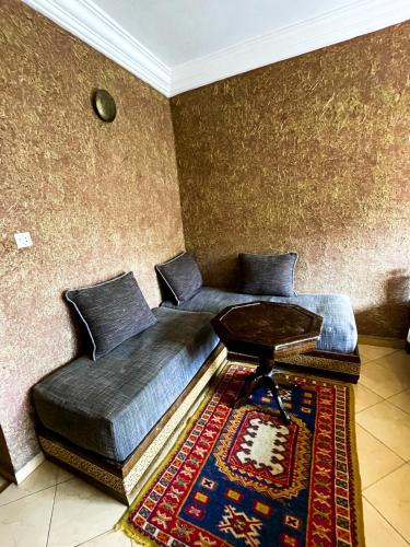 two beds in a room with a table on a rug at tifrit maison d'hôtes-Paradise valley in Imouzzer des Ida Ou Tanane