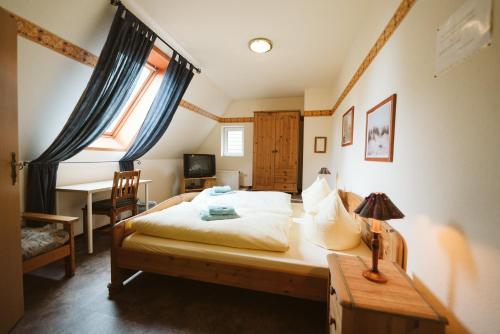 a bedroom with a bed and a desk and a window at Landgasthof Schlotmann in Welver