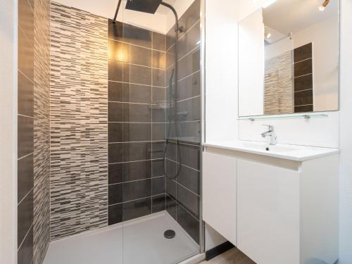 une salle de bain avec une douche avec un lavabo et un miroir dans l'établissement La Dune 73 - Villa 4P9, à Sérignan