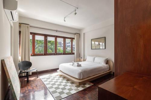 een slaapkamer met een bed, een bureau en een raam bij Timber & Terrace in Bangkok
