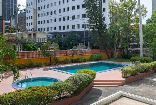 twee zwembaden op een binnenplaats met gebouwen bij Timber & Terrace in Bangkok