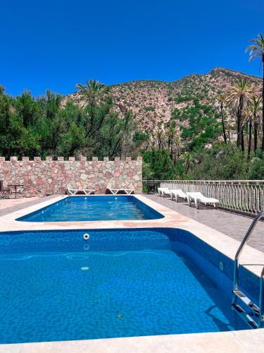 a swimming pool with a mountain in the background at tifrit maison d'hôtes-Paradise valley in Imouzzer des Ida Ou Tanane