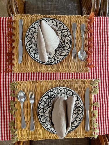 a table with a plate of food with napkins and silverware at tifrit maison d'hôtes-Paradise valley in Imouzzer des Ida Ou Tanane