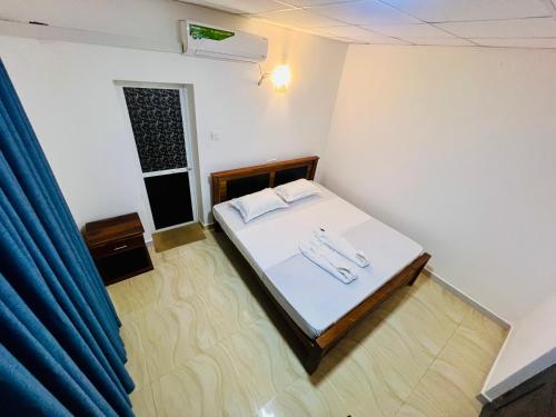 a small room with a bed with white sheets at Lagoon House - Hiriketiya in Dickwella