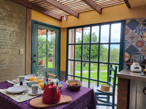 a table with a tea kettle on a purple table cloth at Quinta Paolita in Tumbabiro