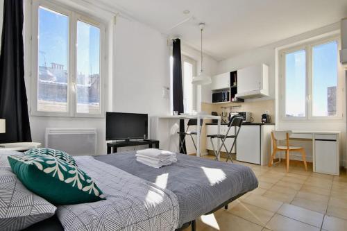 une chambre avec un grand lit et une cuisine dans l'établissement Pied-à-terre idéal au Vieux-Port, à Marseille