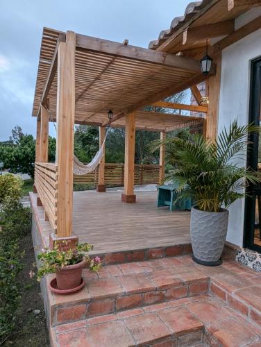 a wooden pergola with a bench on a patio at Quinta Paolita in Tumbabiro