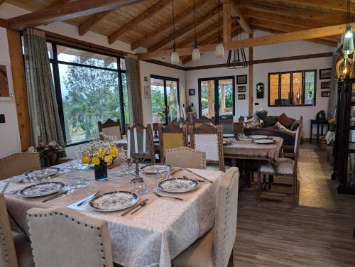 a dining room with tables and chairs and windows at Quinta Paolita in Tumbabiro