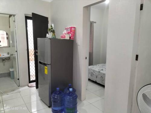 two bottles of water in a room with a refrigerator at comfy bungalow near ateneo de cebu in Mandaue City