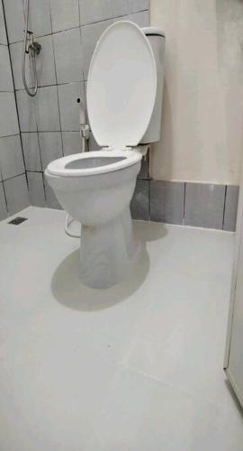 a bathroom with a toilet with the lid up at comfy bungalow near ateneo de cebu in Mandaue City
