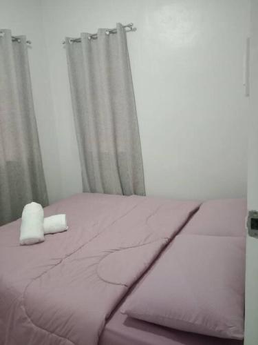 a bed with a white pillow sitting on top of it at comfy bungalow near ateneo de cebu in Mandaue City