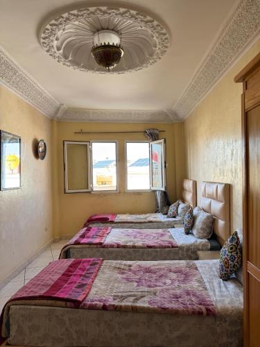 a bedroom with three beds in a room at Dar bennis 2 in Rabat