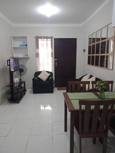 a living room with a table and chairs and a couch at comfy bungalow near ateneo de cebu in Mandaue City