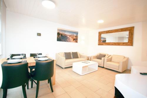 Ferienhaus Pelikanstr 129 Ostermann Bungalow 5 في نورديش: غرفة معيشة بها طاولة وكراسي